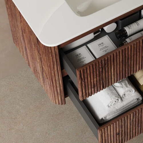 Wooden floating sink vanity with open drawers storing bathroom essentials.