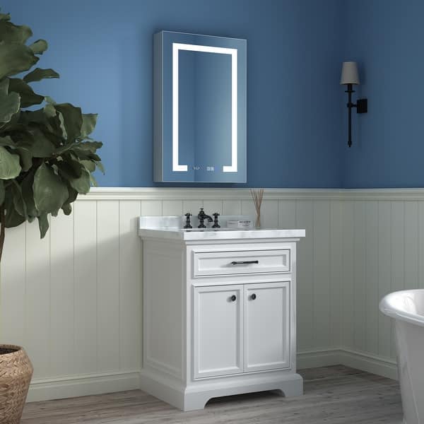 Modern bathroom with LED mirror above white vanity and blue wall decor